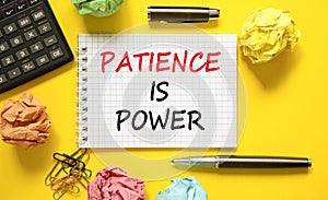 Patience is power symbol. Concept words Patience is power on beautiful white note. Beautiful yellow background. Black pen.