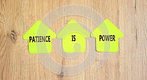 Patience is power symbol. Concept words Patience is power on beautiful yellow paper houses. Beautiful wooden table wooden