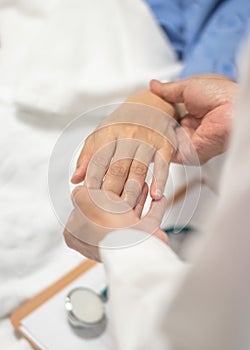 Patient on bed with doctor holding hands for nursing, medical health care, caregiver and in-patient ward healthcare concept