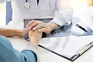 Patient Being Reassured desperate holding hand By Doctor encouraging support and comforting with sympathy. In Hospital Room.