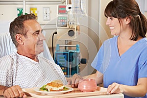 Patient Being Served Meal In Hospital Bed By Nurse