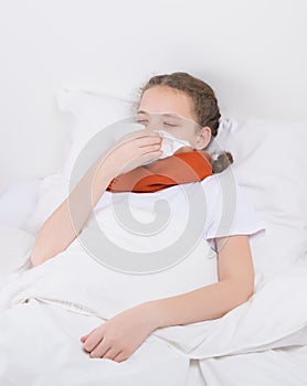 the patient-child lies in bed with a cold and sore throat, blows his nose into a handkerchief