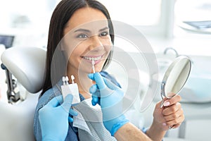 Patient choosing tooth implants with doctor in clinic