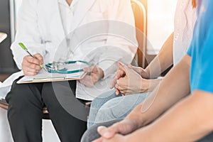 Patient couple consulting with doctor or psychologist on marriage counseling, family medical healthcare therapy, IVF