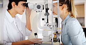 Patient or customer at slit lamp at optometrist or optician photo