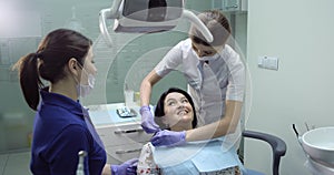 Patient on the dentist room sitting on the chair and open her mouth for a checkup the dentist start to exams the teeth