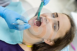 Patient in dentistry with stomatological tools, closeup