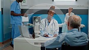 Patient with disability sitting at desk for checkup with medic photo