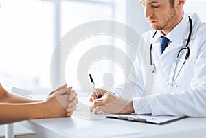 Patient and doctor taking notes photo