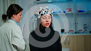 Patient with eeg headset discussing with medical researcher during examination
