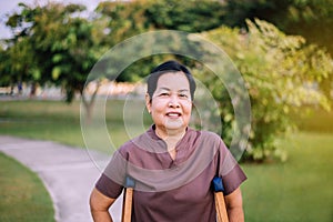 Patient elderly asian woman using crutches support broken legs for walking at public park in the morning ,Physical therapy concept