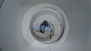 Patient in a Emergency hospital MRI scanner. Man lays in Magnetic Resonance Image device, making tomographic scanning.