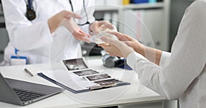 Patient examines silicone breast implants during appointment plastic surgeon