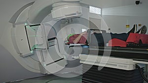 Patient getting radiation therapy treatment inside a modern radiotherapy room