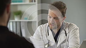 Patient giving paper with medical test results to therapist, healthcare medicine