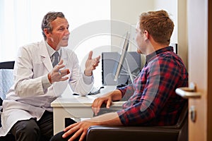 Patient Having Consultation With Male Doctor In Office