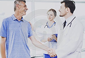 Patient and his Confident Doctor Shake Hands. photo