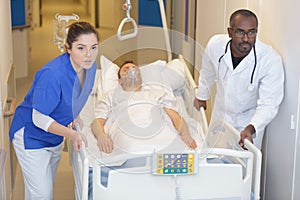 patient hospital bed moved by medical staff to operating room