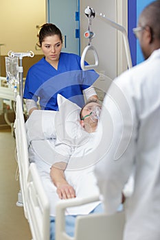 patient hospital bed moved by medical staff to operating room