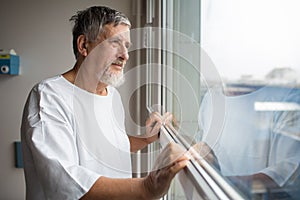 Patient at a hospital, looking from a window in his room