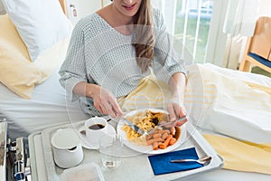 Patient in hospital lying in bed eating meal