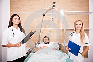 Patient in hospital room next to nurses