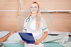 Patient in hospital room next to two nurses