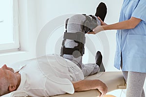 Patient in leg brace in a physiotherapy office