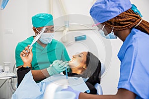 A patient looks at the dentist and looks at her teeth, dental visit