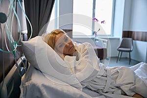 Patient lost in thought during afternoon rest in hospital cot