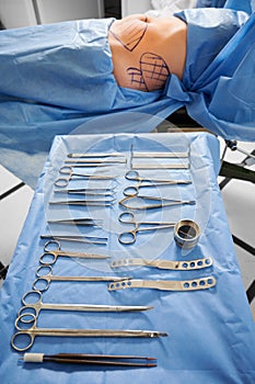 Patient lying near medical instruments in operating room.