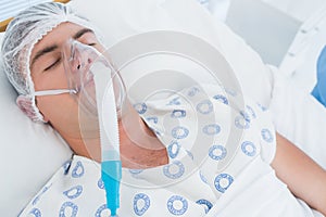 Patient lying with oxygen mask