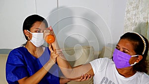 Patient with mask at the physiotherapy doing physical therapy exercises with his therapist