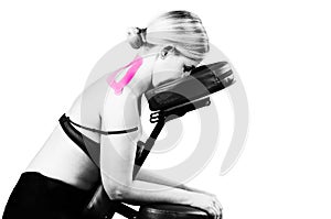 Patient in massage chair with pink kinesio tape in silhouette s