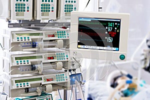 Patient with monitor and infusion pumps in an ICU photo