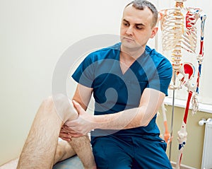 Patient with orthopedist doctor in his office.