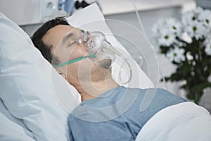 Patient with oxygen mask lying in hospital ward