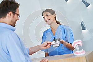 Patient paying for dental visit in clinic