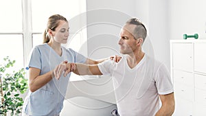 Patient at the physiotherapy doing physical exercises with his therapist