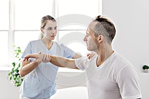 Patient at the physiotherapy doing physical exercises with his therapist