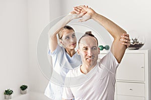 Patient at the physiotherapy doing physical exercises with his therapist