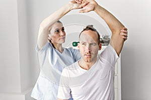 Patient at the physiotherapy doing physical exercises with his therapist