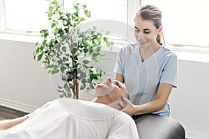 Patient at the physiotherapy doing physical exercises with his therapist