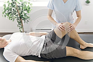 Patient at the physiotherapy doing physical exercises with his therapist