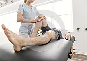 Patient at the physiotherapy doing physical exercises with his therapist photo