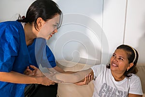 Patient at the physiotherapy doing physical therapy exercises with his therapist