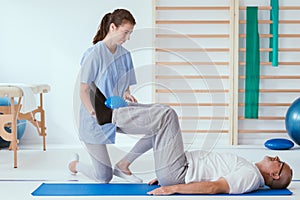 Patient and professional physiotherapist doing muscle stretching exercises