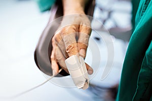 Patient with pulse oximeter on finger for monitoring during surgery