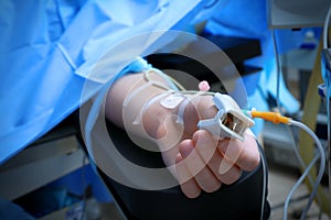 Patient with pulse oxymeter in operating room photo