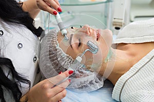 The patient receives procedure Darsonvald. His face is smeared with gel. photo